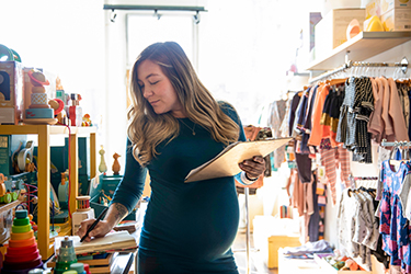 Pregnant working in baby boutique store